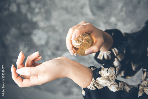 Fotografie woman hand perfume on dark background