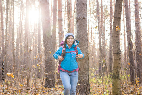 adventure, travel, tourism, hike and people concept - Attractive smiling tourist woman walking in the thick of the forest © satura_
