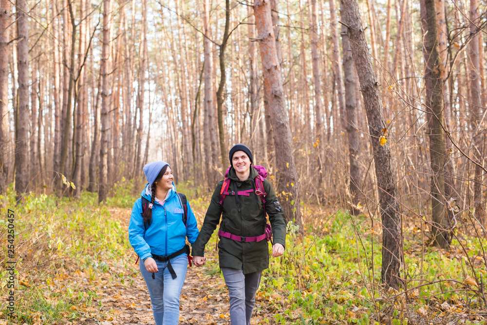 adventure, travel, tourism, hike and people concept - smiling couple walking with backpacks over natural background adventure, travel, tourism, hike and people concept - smiling couple walking with backpacks over natural background