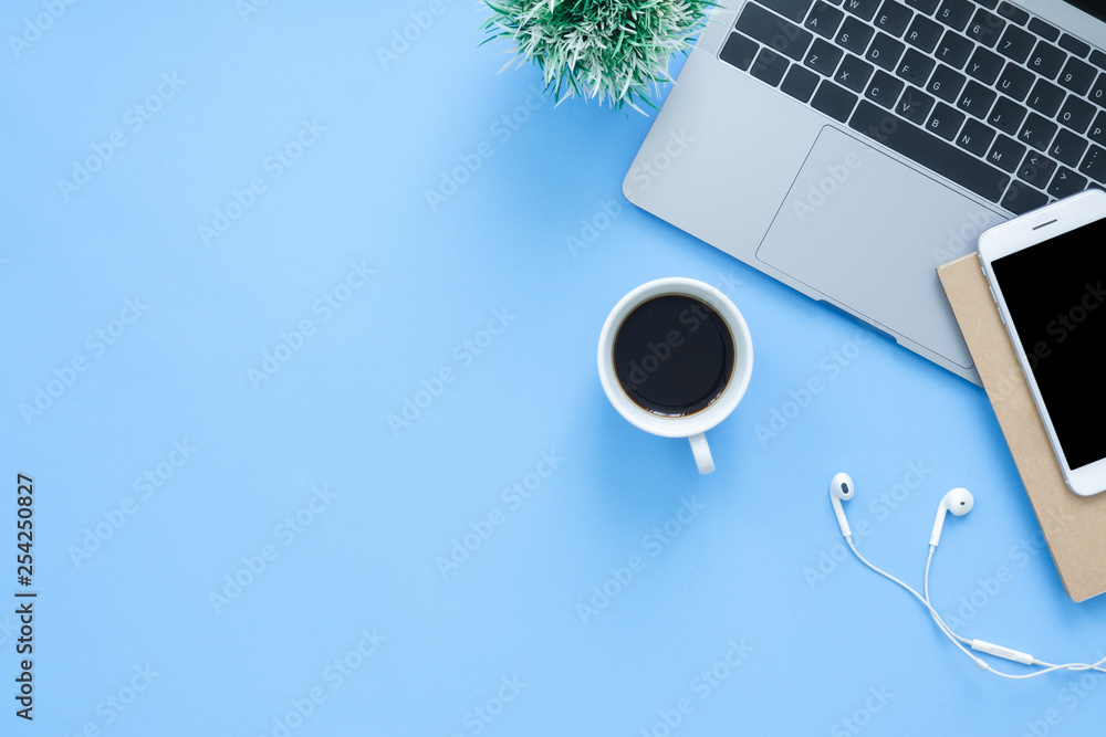 Office desk working space - Flat lay top view mockup photo of working space with laptop, smartphone, coffee up and notebook on blue pastel background. Pastel blue color background working desk concept - obrazy, fototapety, plakaty 