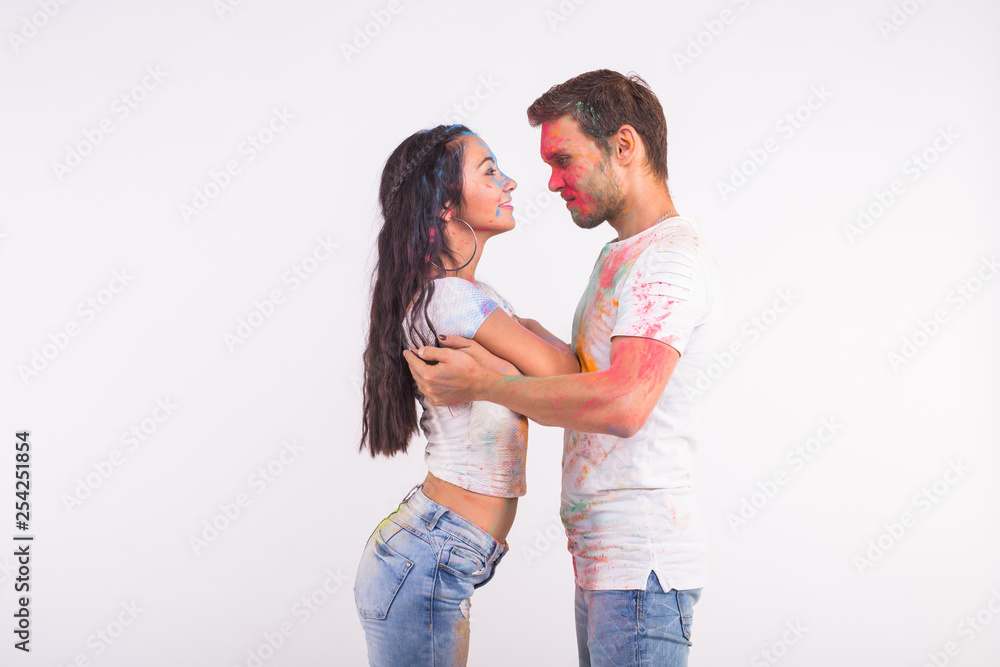 Holiday, social dance, holi and people concept - Happy couple having fun covered in paint and dancing bachata or kizomba on white background Holiday, social dance, holi and people concept - Happy couple having fun covered in paint and dancing bachata or kizomba on white background