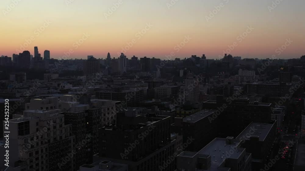 Drone settles down into cluster of buildings in New York City's Harlem neighborhood at daybreak sunrise golden hour. Nice skyline silhouette. in 4K. Drone settles down into cluster of buildings in New York City's Harlem neighborhood at daybreak sunrise golden hour. Nice skyline silhouette. in 4K.