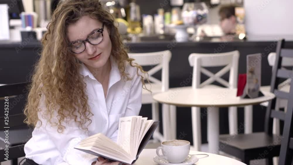 Portrait of a smart and sexy girl in glasses reading book in cafe, weekends leisure. Portrait of a smart and sexy girl in glasses reading book in cafe, weekends leisure.