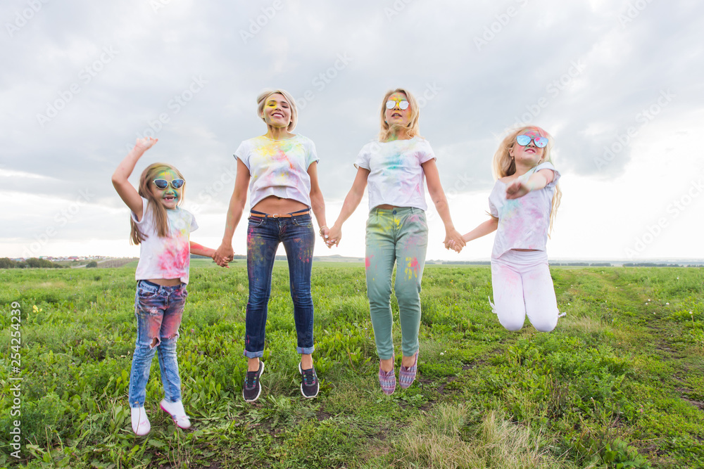 Family, festival of holi and holidays concept - portrait of happy family covered in paint Family, festival of holi and holidays concept - portrait of happy family covered in paint