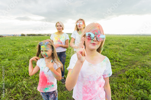 Holi festival  holidays and happiness concept - young teens and women in colors have fun outdoor