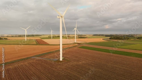 Windturbines during sunset in the south west of the Netherlands. Dynamic aerial shots with sun light. Circling around left to right, same height as subject. photo