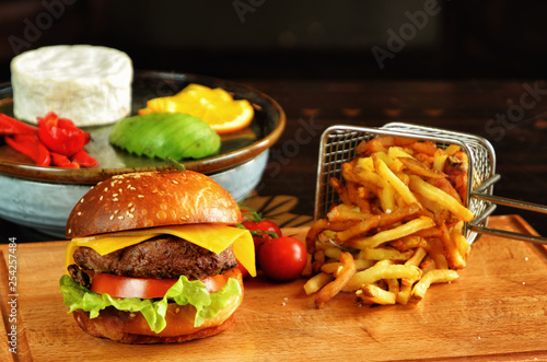 Hamburger and French fries on the wooden tray.