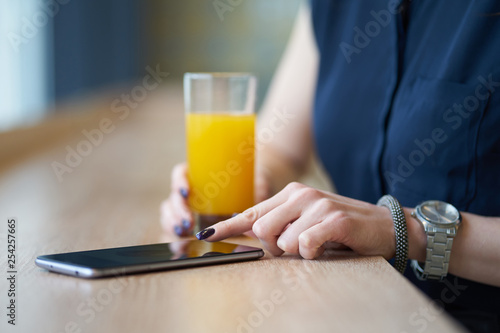 Hands of woman, using smartphone in cafe