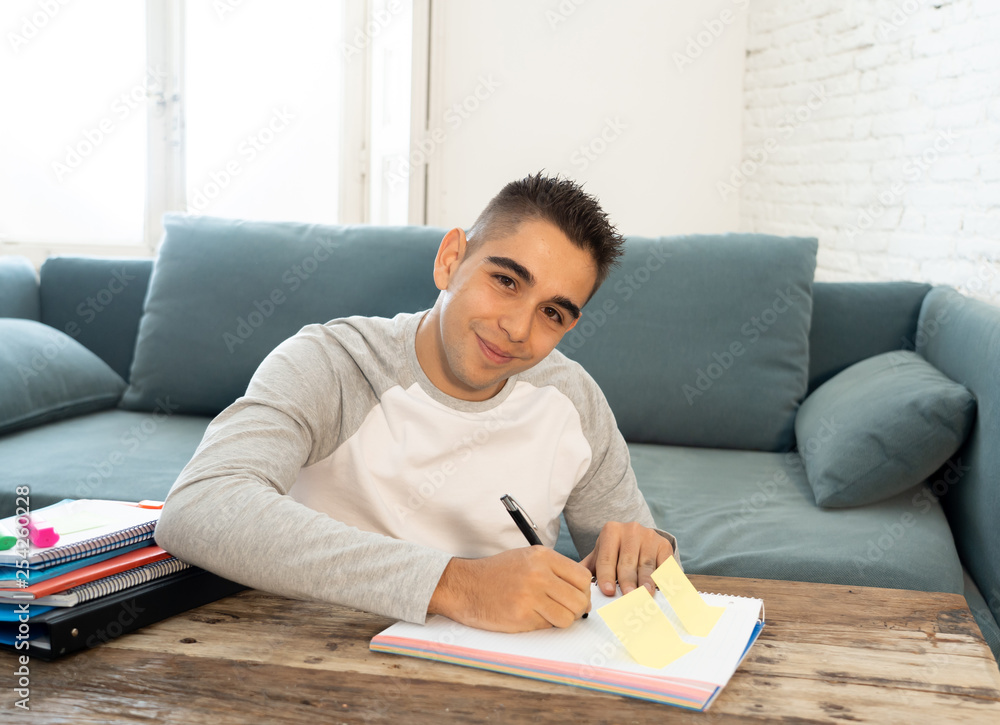Closeup of a happy, cheerful young man studying, working in homework. Learning from books at home Closeup of a happy, cheerful young man studying, working in homework. Learning from books at home