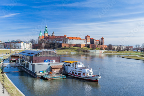 POLAND, KRAKOW - FEBRUARY 23, 2019: Leisure boat with Wawel Royal Castle on background, Vistula River, Poland, February 2019. Sunset cruises, bird watching, wine and cheese cruise.