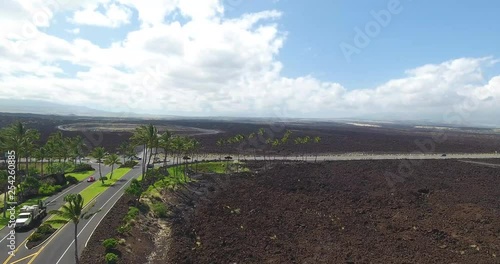 Hawaiian Lava field with long Highway roads, and an intersection with Palm trees. photo