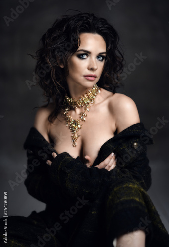 Young sensual beautiful sexy woman posing in spring fashion body jacket and expensive jewelry naked on dark 