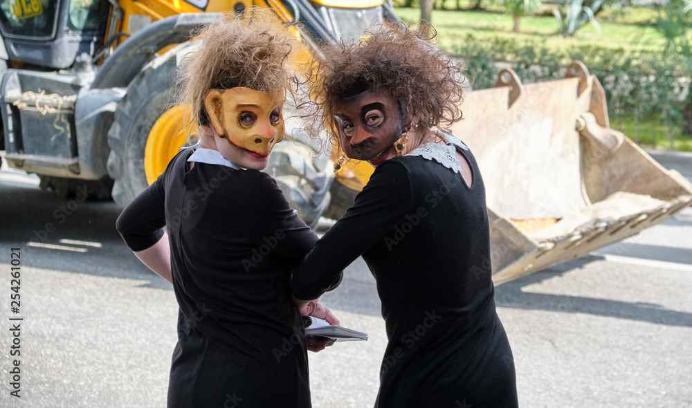 Sochi, Russia - 10 MAR 2019. Two girls in a black dress. Face covered with a monkey mask. Street theatre in Sochi Sochi, Russia - 10 MAR 2019. Two girls in a black dress. Face covered with a monkey mask. Street theatre in Sochi