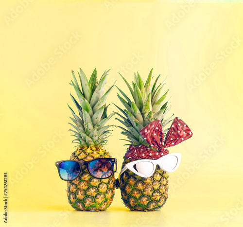 couple in love shopping in a resort on vacation. pineapples with glasses in the form of a guy and a girl on a light background
