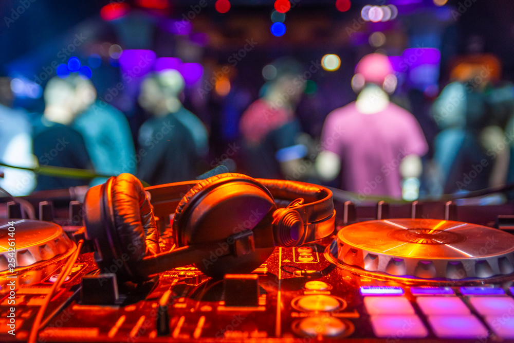 Fototapeta cascos de dj sobre mesa de mezclas en discoteca musica