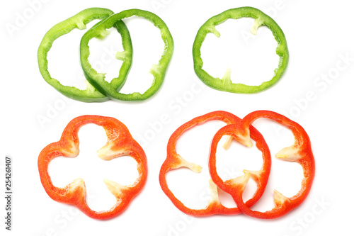 cut slices of red and green sweet bell pepper isolated on white background top view