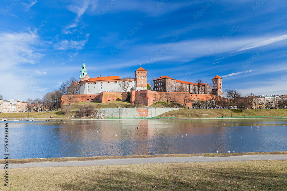 POLAND, KRAKOW - FEBRUARY 23, 2019:  Wawel Castle, a view from the Vistula River. Blue sky and cloud. Gothic cathedral Polish architecture.