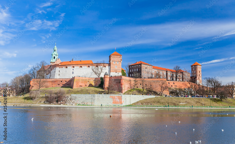 POLAND, KRAKOW - FEBRUARY 23, 2019:  Wawel Castle, a view from the Vistula River. Blue sky and cloud. Gothic cathedral Polish architecture.