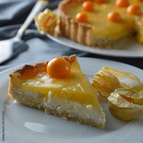 Lemon curd pie. Piece, slice of homemade delicious pie ,tart filled with lemon curd. Sweet dessert. Lemon curd pie decorated with physalis. Square image.
