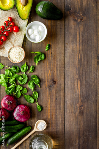 Fresh organic vegetables on dark wooden background top view copy space. Kitchen desk for preparing salad