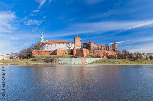POLAND, KRAKOW - FEBRUARY 23, 2019: Wawel Castle, a view from the Vistula River. Blue sky and cloud. Gothic cathedral Polish architecture.