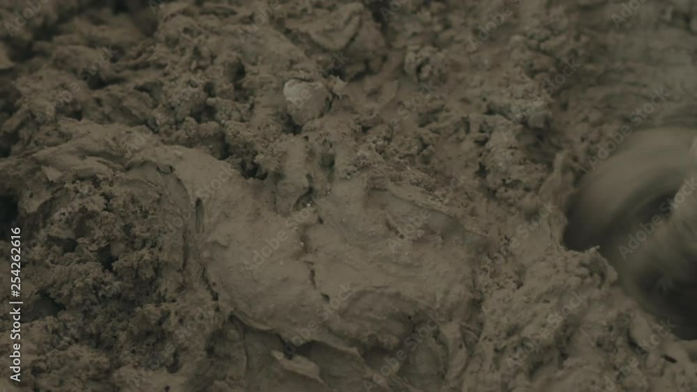 Slow motion pan shot of mixing concrete plaster with electric mixer Slow motion pan shot of mixing concrete plaster with electric mixer