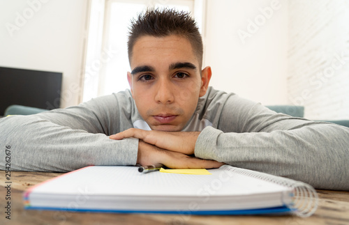 Obraz na plátně Overworked and tired high school student man studying home feeling depressed and