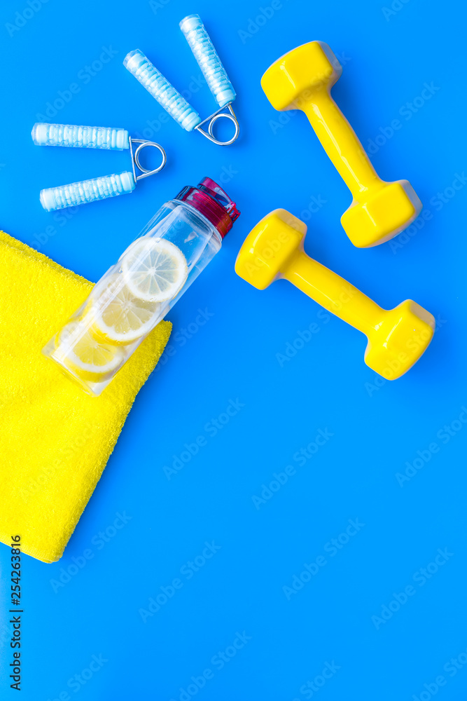 Fitness background with sport equipment for gym and home on blue background top view copyspace Fitness background with sport equipment for gym and home on blue background top view copyspace