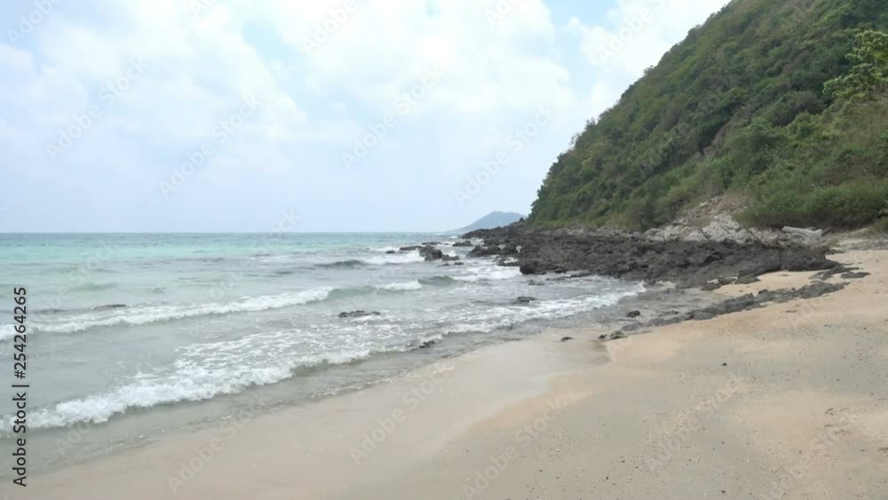 Inviting deserted beach next to a foliage covered cliff on a tropical vacation destination. Inviting deserted beach next to a foliage covered cliff on a tropical vacation destination.