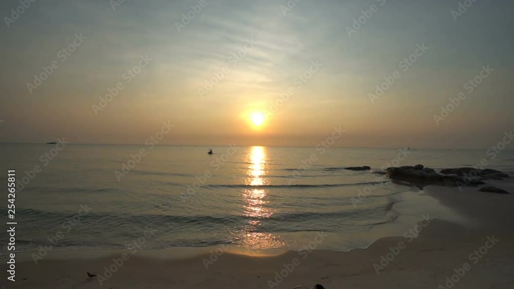 The waves lapping up onto a tropical beach, as the sun sets over the ocean in Thailand. The waves lapping up onto a tropical beach, as the sun sets over the ocean in Thailand.