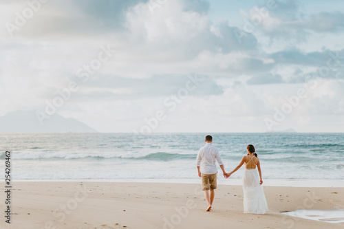 honeymoon wedding couple on beach at sunset