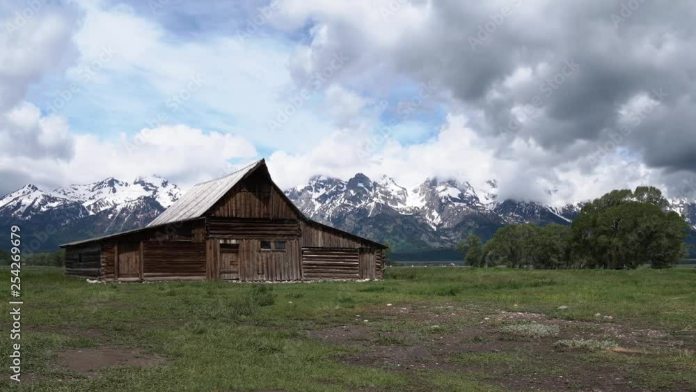 Antique Moulton Barn on a stormy day with snow capped mountains in the distance on Mormon Row in Grand Teton National Park, Wyoming Antique Moulton Barn on a stormy day with snow capped mountains in the distance on Mormon Row in Grand Teton National Park, Wyoming