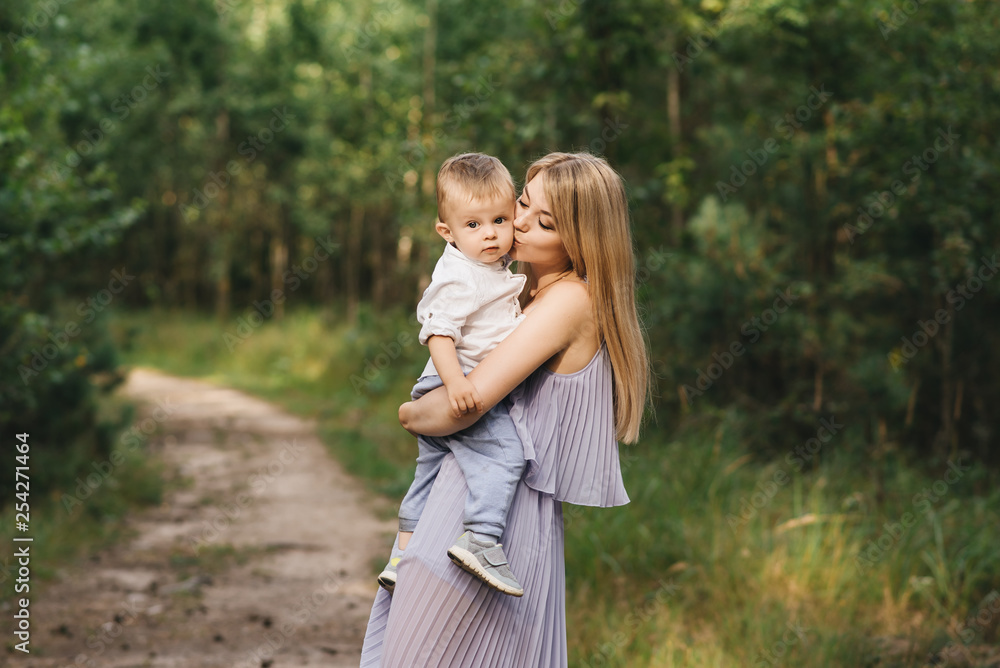 Happy young family spends time together in nature. Sweet mother with baby Happy young family spends time together in nature. Sweet mother with baby