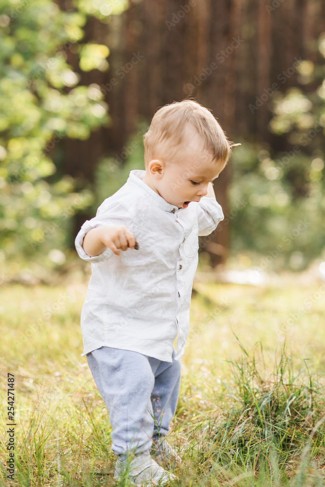 Cute boy playing in nature. Summer in the forest Cute boy playing in nature. Summer in the forest