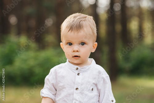 Cute boy playing in nature. Summer in the forest