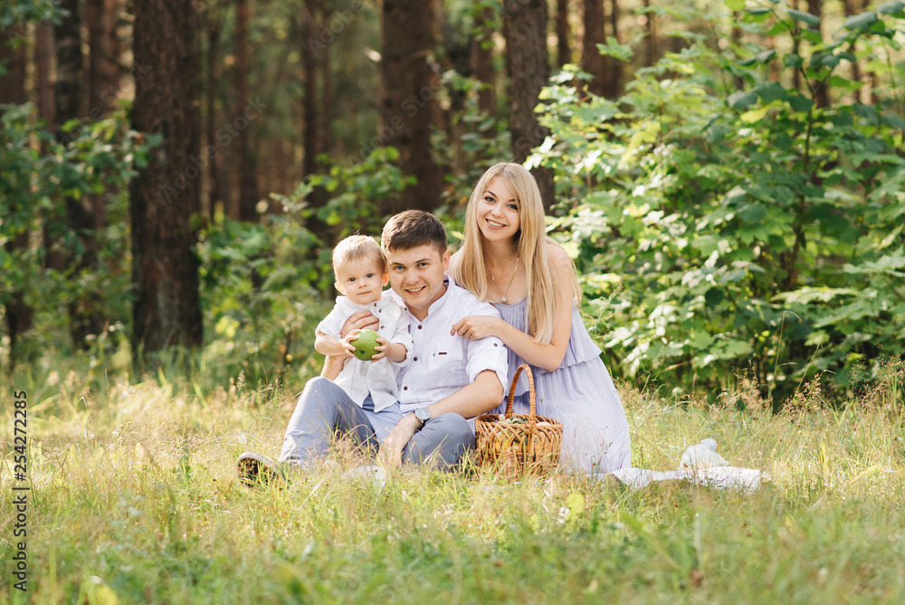 Happy young family spends time together in nature. Picnic in the forest Happy young family spends time together in nature. Picnic in the forest