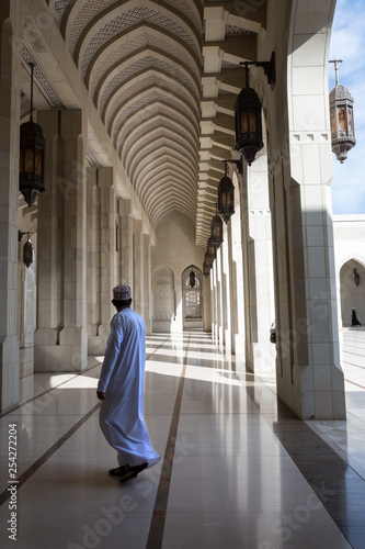an Arab man walking through the archway of a historic building
