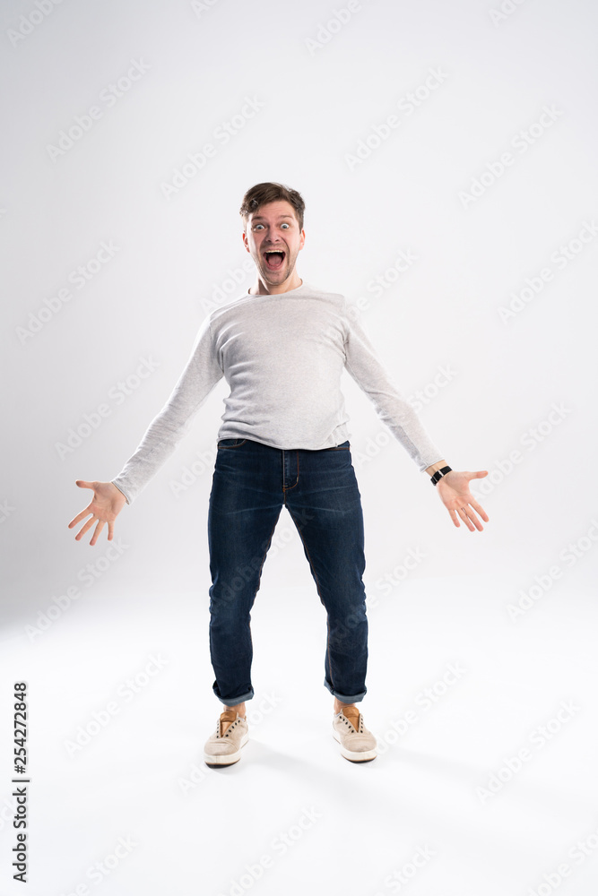 Happy winner. Full length portrait of happy young handsome man gesturing and keeping mouth open while standing against white background. Happy winner. Full length portrait of happy young handsome man gesturing and keeping mouth open while standing against white background.