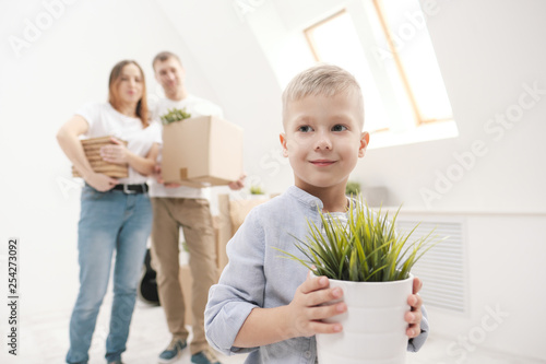 Young family, man woman and child son in new apartments. Boxes with cargo on a white background. © spaskov