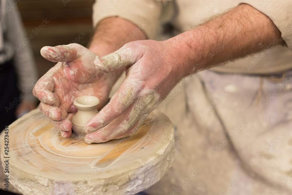 Potter's hands at work close-up. Potter working clay on potter's wheel . Craft, hobby