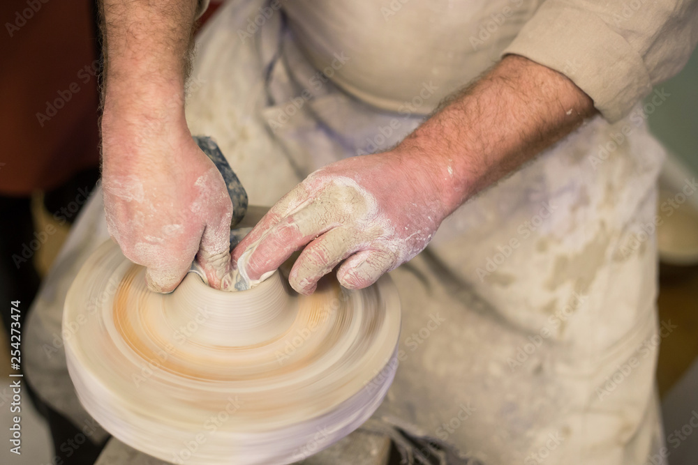Potter's hands at work. Potter working clay on potter's wheel. Craft concept