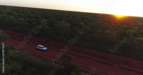 Drone tracks a white 4WD at sunrise / sunset deep in far north Western Australia. photo