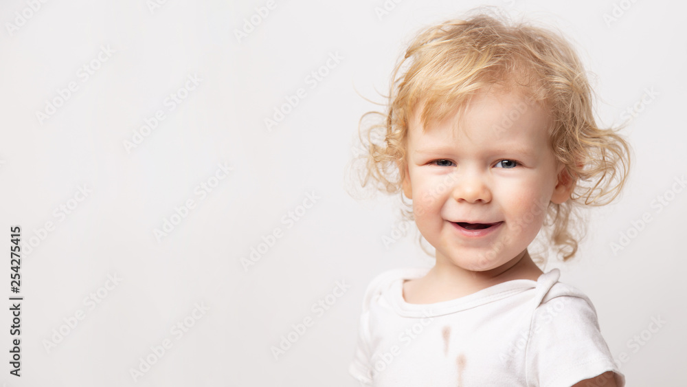 banner portrait of cute caucasian smiling curly baby girl in dirty white clothes t-shirt on white background. banner portrait of cute caucasian smiling curly baby girl in dirty white clothes t-shirt on white background.