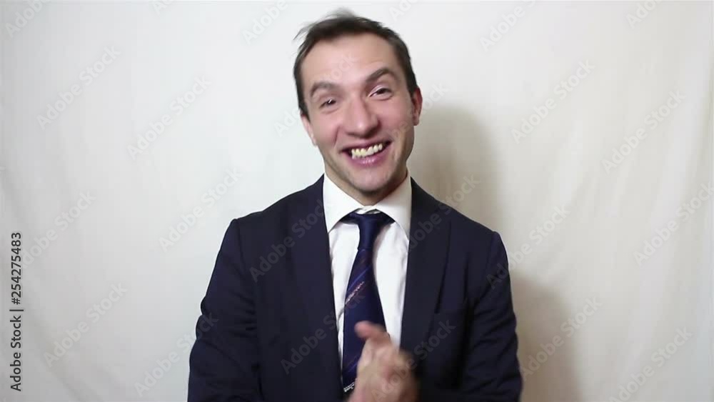 Handsome young businessman smiling and actively clapping hands, greeting new customers.Portrait on a white background. Handsome young businessman smiling and actively clapping hands, greeting new customers.Portrait on a white background.