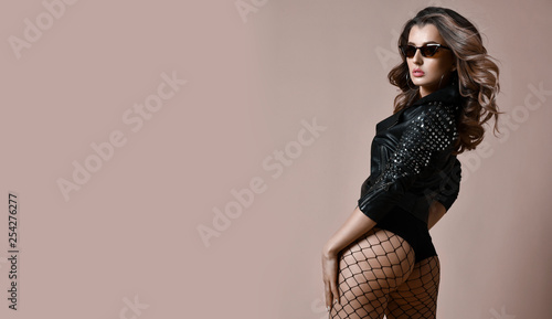 Young sensual beautiful sexy woman posing in fashion black leather jacket with nice ass buttocks and fashion sunglasses photo