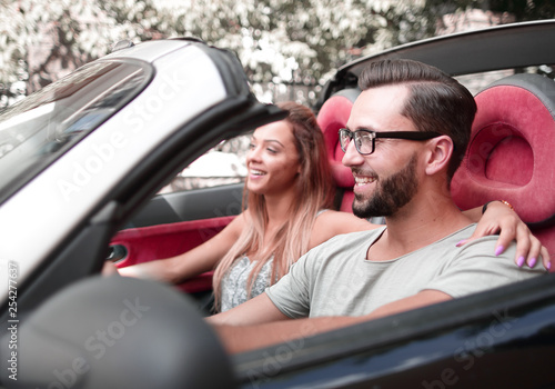 loving couple sitting in the front seat of a convertible car © ASDF