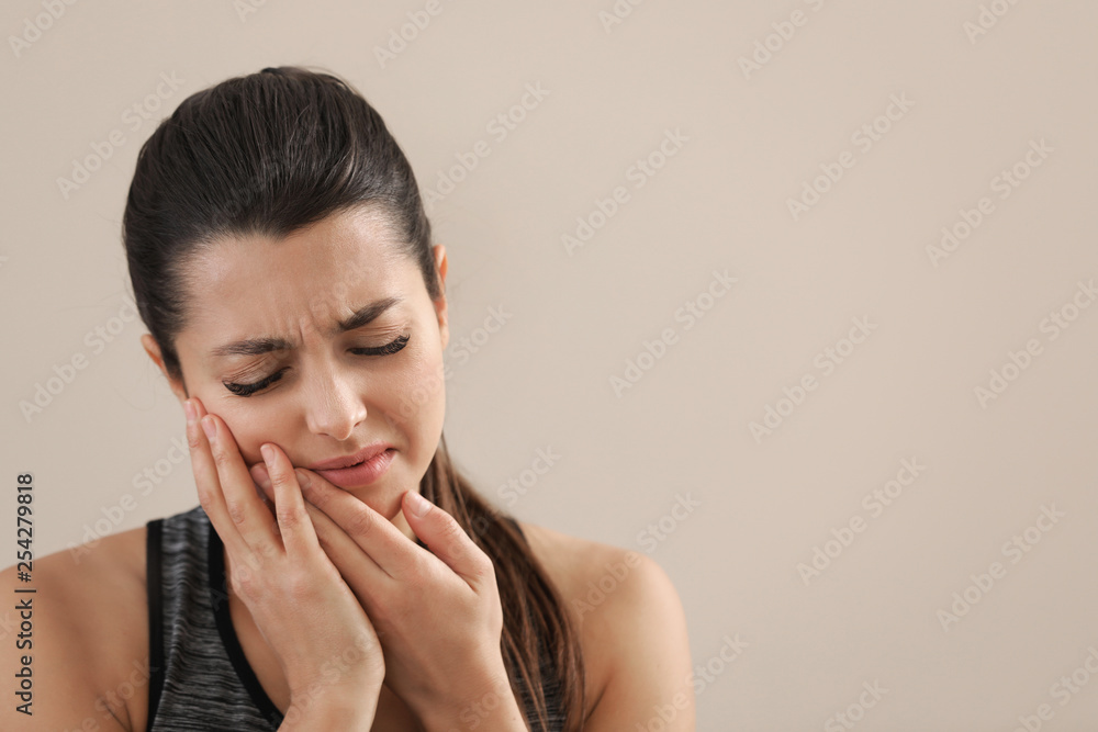 Young woman with sensitive teeth on color background. Space for text Young woman with sensitive teeth on color background. Space for text
