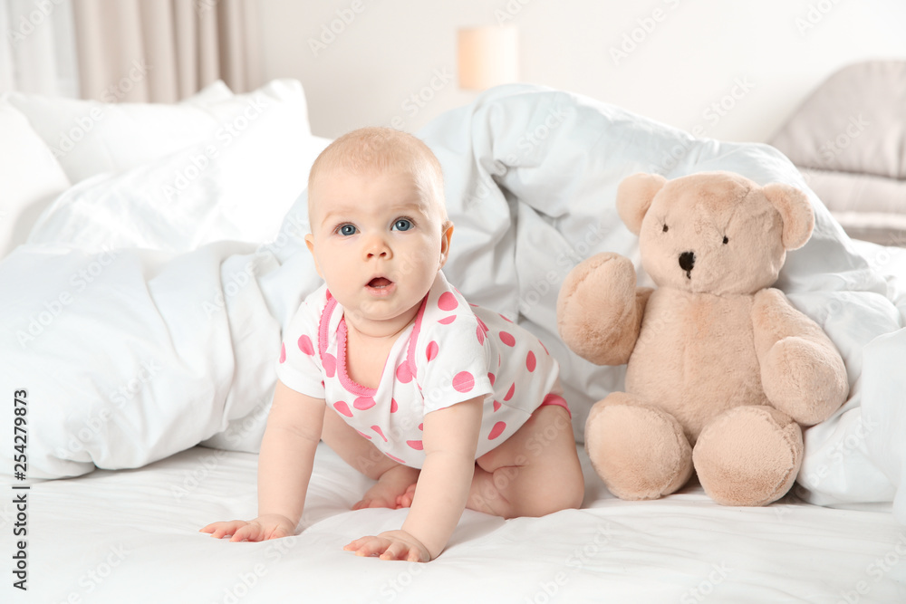 Cute baby girl with toy on bed at home. Bedtime schedule Cute baby girl with toy on bed at home. Bedtime schedule