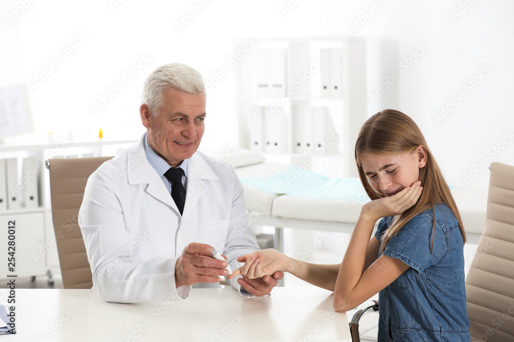 Doctor taking patient's blood sample with lancet pen in hospital. Diabetes control Doctor taking patient's blood sample with lancet pen in hospital. Diabetes control