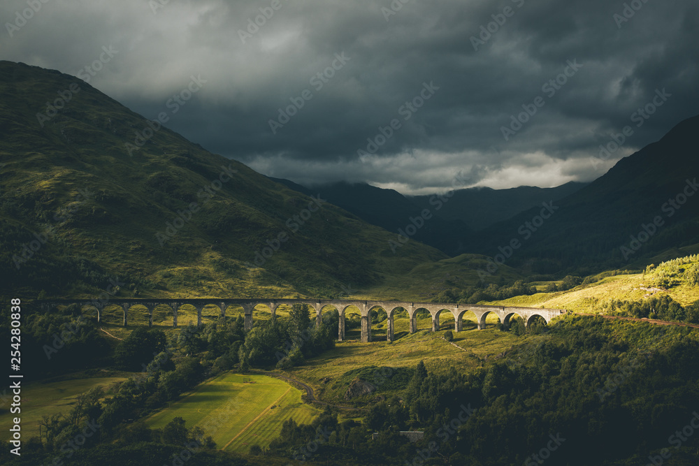 Naklejka premium Famous bridge of glenfinnan railway viaduct highlands scotland tourist attraction Located at the top of Loch Shiel in the West Highlands of Scotland, the viaduct overlooks the Glenfinnan Monument